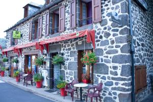a stone building with tables and chairs on a street at Hotel De La Poste in Saint-Martin-sous-Vigouroux +20 photos