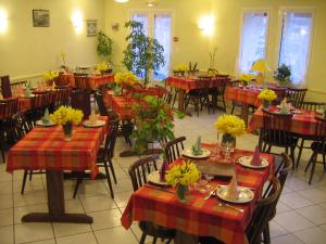 een eetkamer met tafels en stoelen met bloemen erop bij Hotel De La Poste in Saint-Martin-sous-Vigouroux