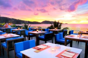 un restaurante con vistas al océano al atardecer en La Flora Resort Patong - SHA Extra Plus, en Patong Beach