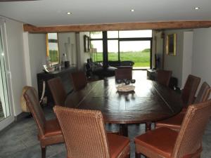 a dining room with a wooden table and chairs at Au Bonheur Frontalier in Steenvoorde
