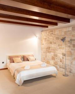 - une chambre avec 2 lits et un mur en pierre dans l'établissement Luxurious city retreat with pool, à Šibenik