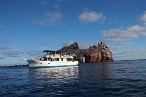 un barco en el agua cerca de una pequeña isla en El Duque Adventures, en La Paz