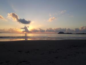 um pôr-do-sol numa praia com o oceano em Pousada Villa Maria na Ilha do Mel