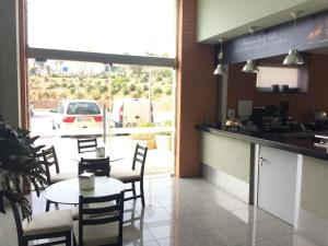 a restaurant with a table and chairs and a view of a parking lot at Ericeira Surf and Sun in Ericeira