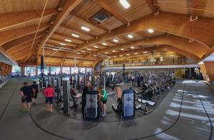 un gimnasio con la gente haciendo ejercicio en el gimnasio en Cooper Hotel Conference Center & Spa en Dallas