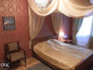 メリトポリにあるApartment on Alexeyevaのベッドルーム1室(ベッド1台、椅子、窓付)