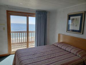 a bedroom with a bed and a view of the ocean at Algoma Beach Motel in Algoma