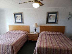 a hotel room with two beds and a table with a lamp at Algoma Beach Motel in Algoma