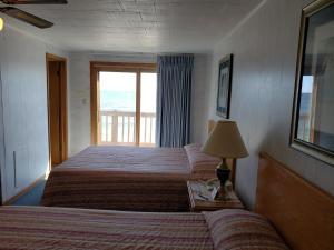 um quarto de hotel com duas camas e uma janela em Algoma Beach Motel em Algoma