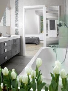 a bathroom with a white tub and white flowers at Appartements Le 32 in Strasbourg +14 photos