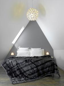 1 dormitorio con 1 cama con manta blanca y negra en Appartements Le 32 en Estrasburgo