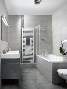 a bathroom with a sink and a tub and a toilet at Appartements Le 32 in Strasbourg