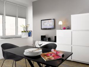 a dining room with a black table and chairs at Appartements Le 32 in Strasbourg
