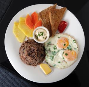 een bord ontbijtproducten met eieren, brood en toast bij Oceano Boutique Hotel & Gallery in Jacó