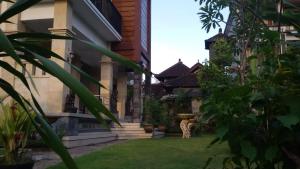 une maison avec une cour avec de l'herbe verte dans l'établissement Murdhasari, à Ubud