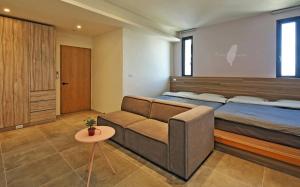ein Schlafzimmer mit einem Bett und einer Couch in der Unterkunft Less is more in Wujie