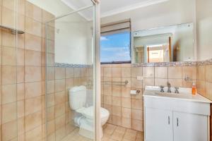 a bathroom with a toilet and a sink and a mirror at Queensland South - Aldinga Beach - C21 SouthCoast Holidays in Aldinga Beach
