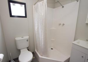 a white toilet sitting next to a bath tub at Marysville Holiday Park in Marysville