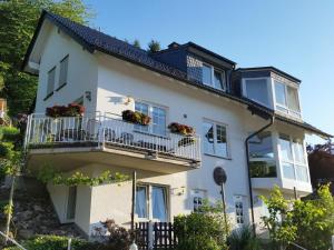 Una casa blanca con balcones y flores. en Ferienwohnung Pollig, en Rech