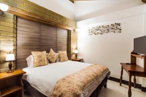 a bedroom with a large bed and a television at Hotel El Giro in Villa de Leyva