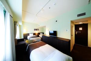 Ένα ή περισσότερα κρεβάτια σε δωμάτιο στο Ginza Grand Hotel