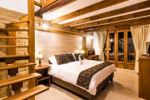 a bedroom with a bed in a room with wooden walls at Hotel El Giro in Villa de Leyva