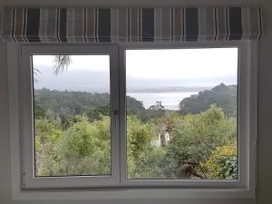 uma janela com vista para o oceano em Fernglen B&B em Auckland