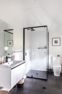 a bathroom with a shower and a sink and a toilet at Bendooley Estate in Berrima