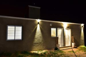 una casa con luces al costado de ella por la noche en Departamento Pircas in 