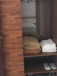 a closet with a shelf with folded towels on it at Feng Xian Bai Hua B&B in Guanshan