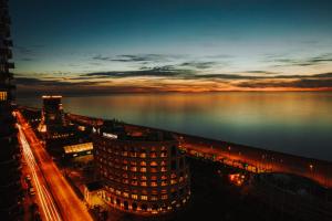 a view of a city at night with the water at Blue Star Batumi in Batumi