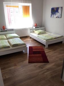 een slaapkamer met 2 bedden en een tapijt bij Ferienwohnung Sandow in Cottbus