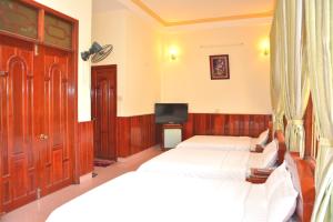 Llit o llits en una habitació de Hai Huong Hotel