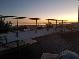 a balcony with chairs and a sunset in the background at Alvor Ria Apartment in Alvor