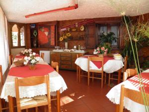 a kitchen with two tables with red and white table cloth at Parco Delle Tre Fontane in Nicolosi