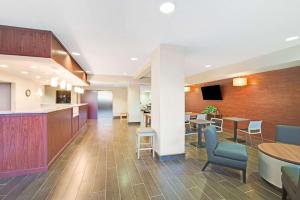een lobby van een ziekenhuis met tafels en stoelen bij Microtel Inn & Suites Urbandale in Urbandale