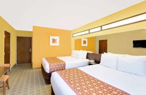 a hotel room with two beds and a television at Microtel Inn & Suites by Wyndham Princeton in Princeton +12 photos