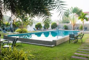 uma piscina com cadeiras e mesas num quintal em Cozy Resort, A Boutique Hotel em South Pattaya