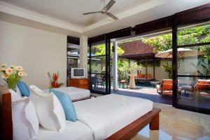 a bedroom with two beds and a living room at Temple Hill Residence Villa in Jimbaran