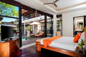 a bedroom with a bed and a tv and a pool at Temple Hill Residence Villa in Jimbaran