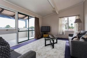 uma sala de estar com um sofá e uma televisão em Blenheim Road Motor Lodge em Christchurch