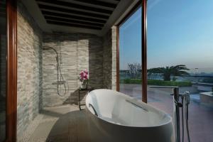 uma banheira em um banheiro com uma janela grande em Melia Yangon em Yangon