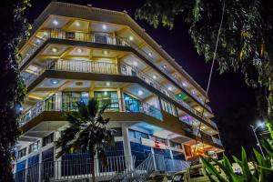 a tall building with balconies at night at The Joy Hotel in Voi