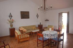 a living room with a table and chairs and a couch at GBH Casas Fimbapaire in La Oliva