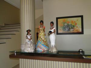 Tre bambole sono sedute su uno scaffale di vetro di Hotel Cambui a Seabra