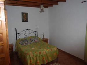 ein Schlafzimmer mit einem Bett mit einer grünen Bettdecke in der Unterkunft GBH Casas Fimbapaire in La Oliva