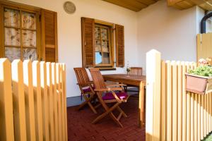 une terrasse couverte avec une table et des chaises en bois ainsi qu'une clôture dans l'établissement Apartma Marjetica 2, à Moravske Toplice