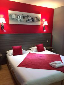 カルクフーにあるThe Originals City, Hôtel La Closerie, Nantes Nord (Inter-Hotel)の赤い壁のベッドルーム1室(大型ベッド1台付)