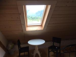 einen Tisch und zwei Stühle in einem Zimmer mit Fenster in der Unterkunft Vila Mangart in Bled