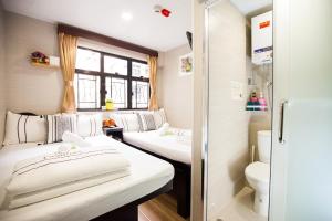 a small room with two beds and a toilet at Comfort Guest House in Hong Kong